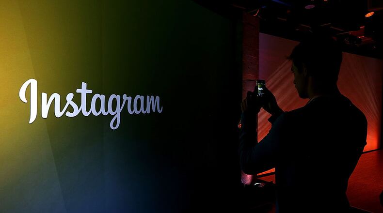 MENLO PARK, CA - JUNE 20: An attendee takes a photo of the instagram logo during a press event at Facebook headquarters on June 20, 2013 in Menlo Park, California. Facebook announced that its photo-sharing subsidiary Instagram will allow users to take and share video. (Photo by Justin Sullivan/Getty Images)