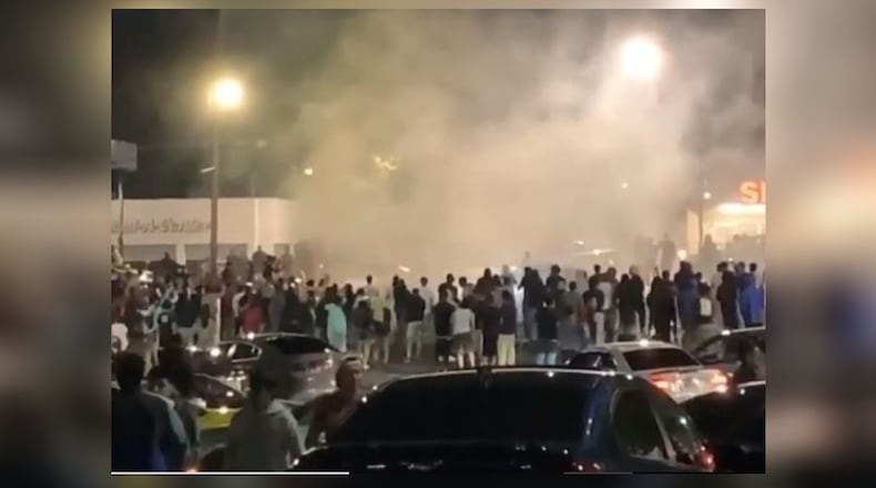 In one video, posted on Saturday, a large crowd is gathered in the parking lot of The Mall West End while cars do doughnuts and burnouts.
