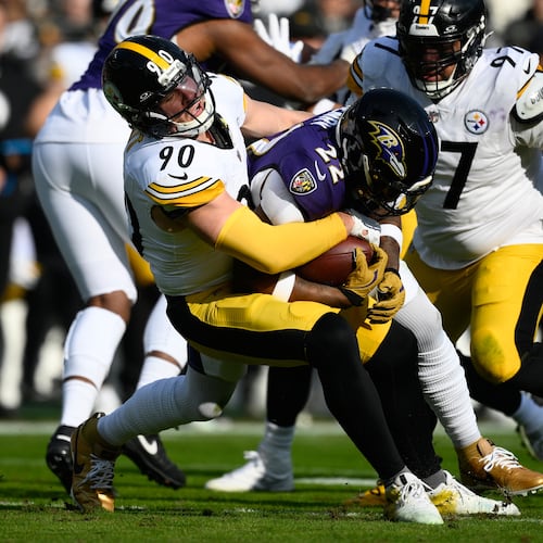 Pittsburgh Steelers linebacker T.J. Watt (90) tackles Baltimore Ravens running back Derrick Henry (22) during the first half of an NFL football game, Sunday, Dec. 7, 2025, in Baltimore. (AP Photo/Nick Wass)