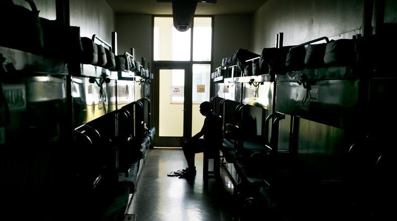 A man awakes from his assigned bed in the transition area at the Austin Resource Center for the Homeless in downtown Austin, Texas.
