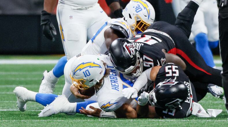 Atlanta Falcons linebacker Kaden Elliss (55) lays on the ground after sacking Los Angeles Chargers quarterback Justin Herbert (10) during the first half of an NFL football game against the Los Angeles Chargers on Sunday, December 1, 2024, at Mercedes-Benz Stadium in Atlanta. 
(Miguel Martinez/ AJC)
