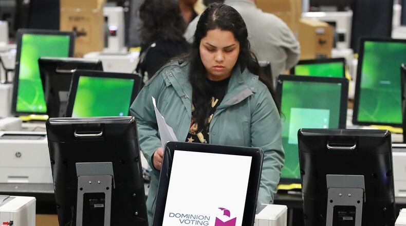 A worker helps test and pack thousands of Georgia’s new voting machines last month in a metro Atlanta warehouse. Curtis Compton ccompton@ajc.com