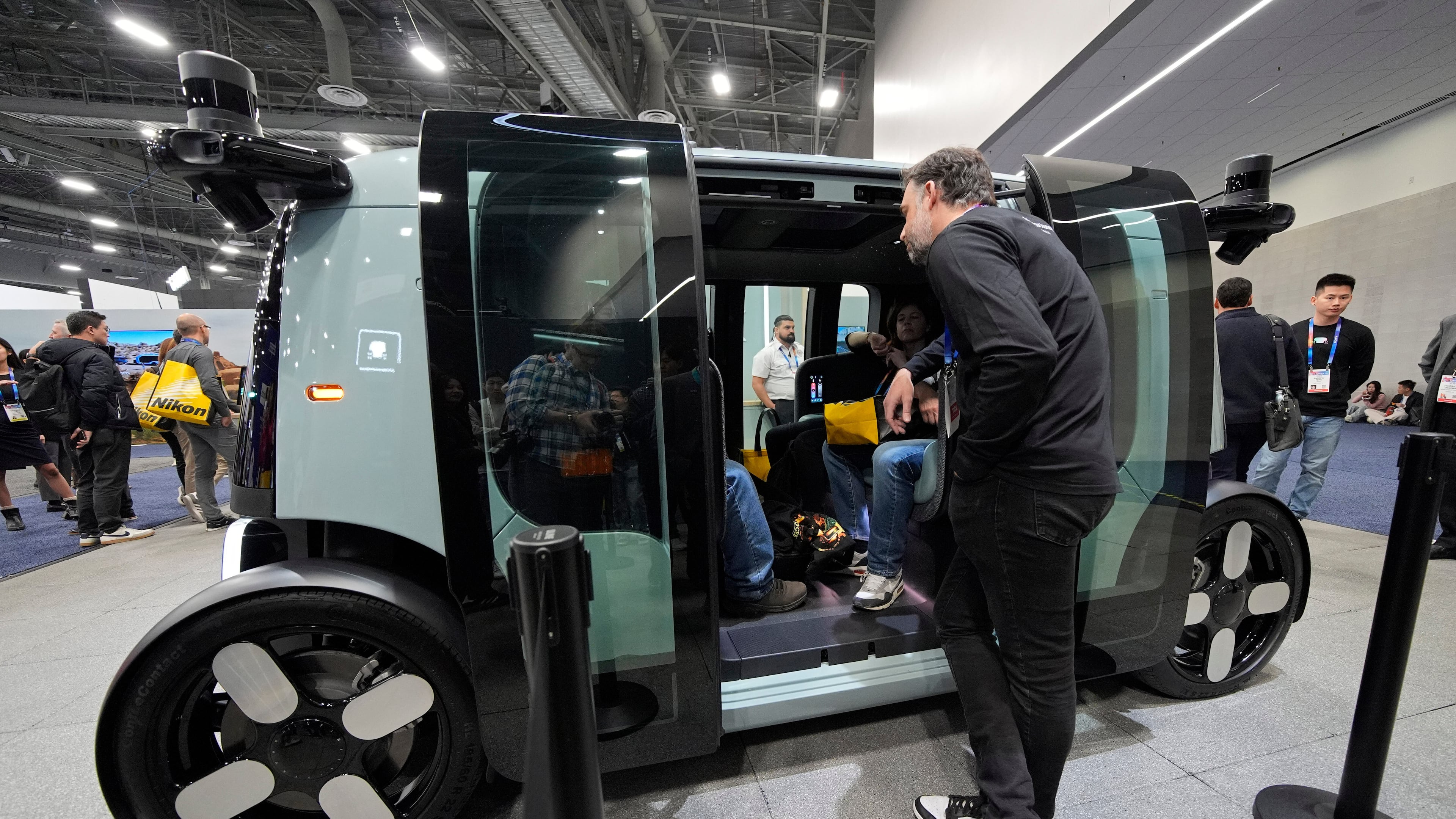 FILE - People view a Zoox self-driving vehicle at the Zoox booth during the CES tech show, Jan. 7, 2025, in Las Vegas. (AP Photo/John Locher, file)