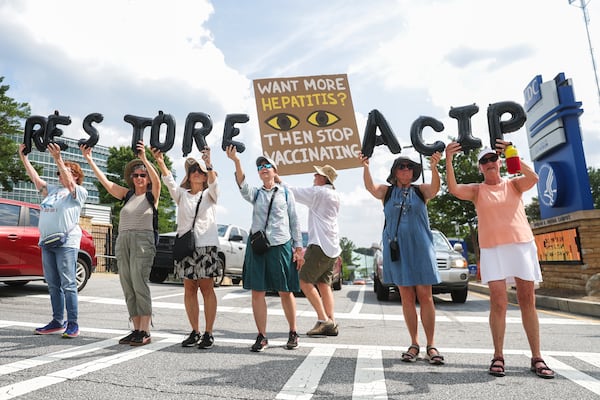 A group of women holds balloons that read, “Restore ACIP,” in front of the CDC in Atlanta on Wednesday, June 25, 2025. (Abbey Cutrer/AJC)