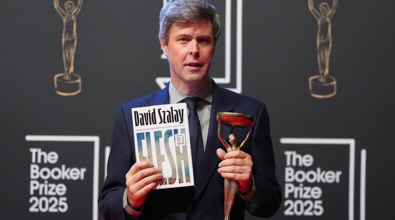 Hungarian-British author David Szalay poses for photographers with the trophy after winning the Booker Prize 2025 for his book 'Flesh' during a ceremony at Old Billingsgate in London, Monday, Nov. 10, 2025. (AP Photo/Kirsty Wigglesworth)