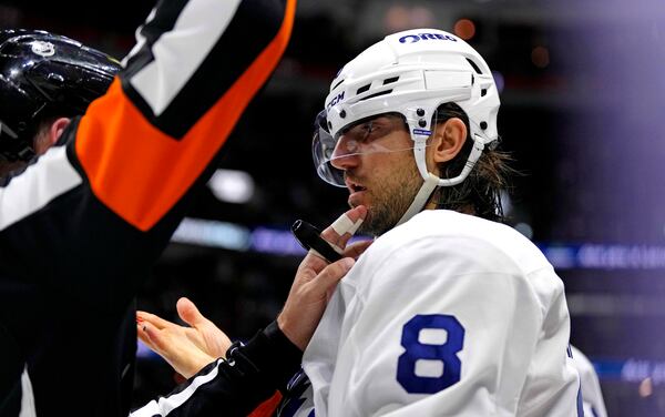 The referee, left, touches the face of Toronto Maple Leafs' Chris Tanev (8) who shows blood on his fingers, leading to a double minor penalty against Ottawa Senators' Drake Batherson during overtime of Game 4 of an NHL hockey Stanley Cup first-round playoff series in Ottawa, Ontario, Saturday, April 26, 2025. (Justin Tang/The Canadian Press via AP)