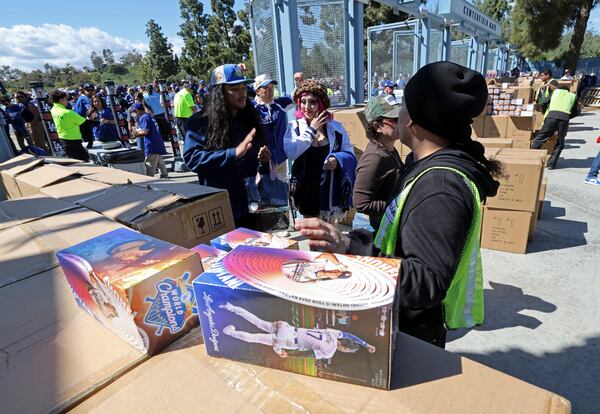 Fans arrive at Dodger Stadium to receive a bobblehead doll of Los Angeles Dodgers' Shohei Ohtani before a baseball game against the Atlanta Braves Wednesday, April 2, 2025, in Los Angeles. (AP Photo/Kevork Djansezian)