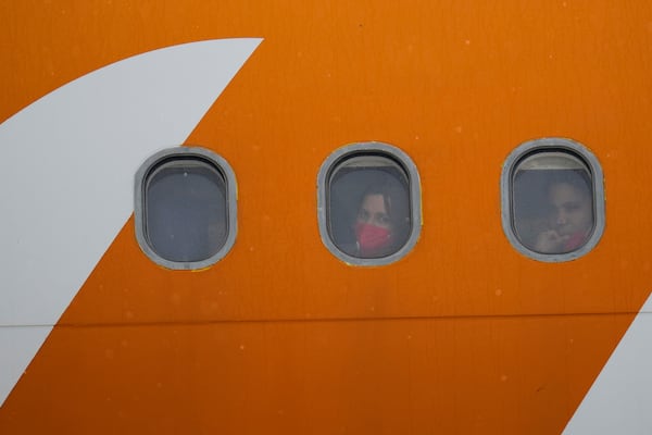 Venezuelan migrants deported from the United States look out from plane portholes upon landing at the Simon Bolivar International Airport in Maiquetia, Venezuela, Friday, May 2, 2025. (AP Photo/Ariana Cubillos)