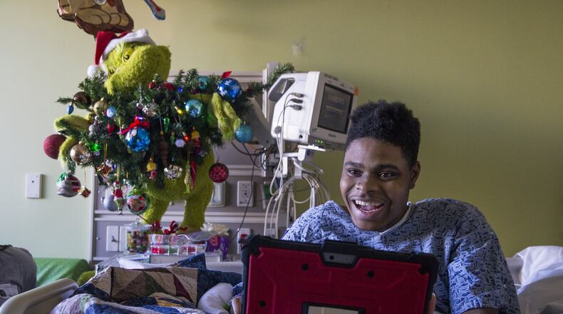 Patient Steffon Boyd, 17, of Dalton uses a tablet to control an OhmniLabs robot on his floor at the Children’s Healthcare of Atlanta at Scottish Rite on Dec. 19, 2019. Boyd uses the robot to interact with people and participate in group activities in the Child Life Zone Network at the hospital. (ALYSSA POINTER/ALYSSA.POINTER@AJC.COM)