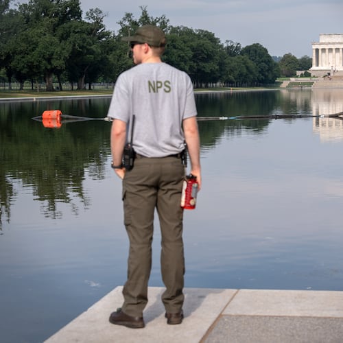 FILE - A National Park Service worker stands near a pump placed next to the Lincoln Memorial Reflecting Pool in Washington, July 10, 2026. (AP Photo/Mark Schiefelbein, File)