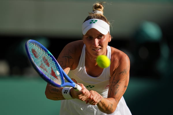 Marketa Vondrousova of the Czech Republic plays a return to Emma Raducanu of Britain during their second round women's singles match at the Wimbledon Tennis Championships in London, Wednesday, July 2, 2025.(AP Photo/Kirsty Wigglesworth)