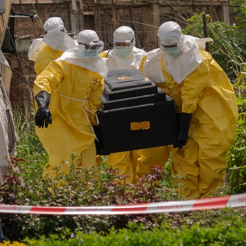 A woman cries as Red Cross workers carry the coffin of a person who died of Ebola from a health center in Rwampara, Congo, Wednesday, May 20, 2026. (AP Photo/Moses Sawasawa)