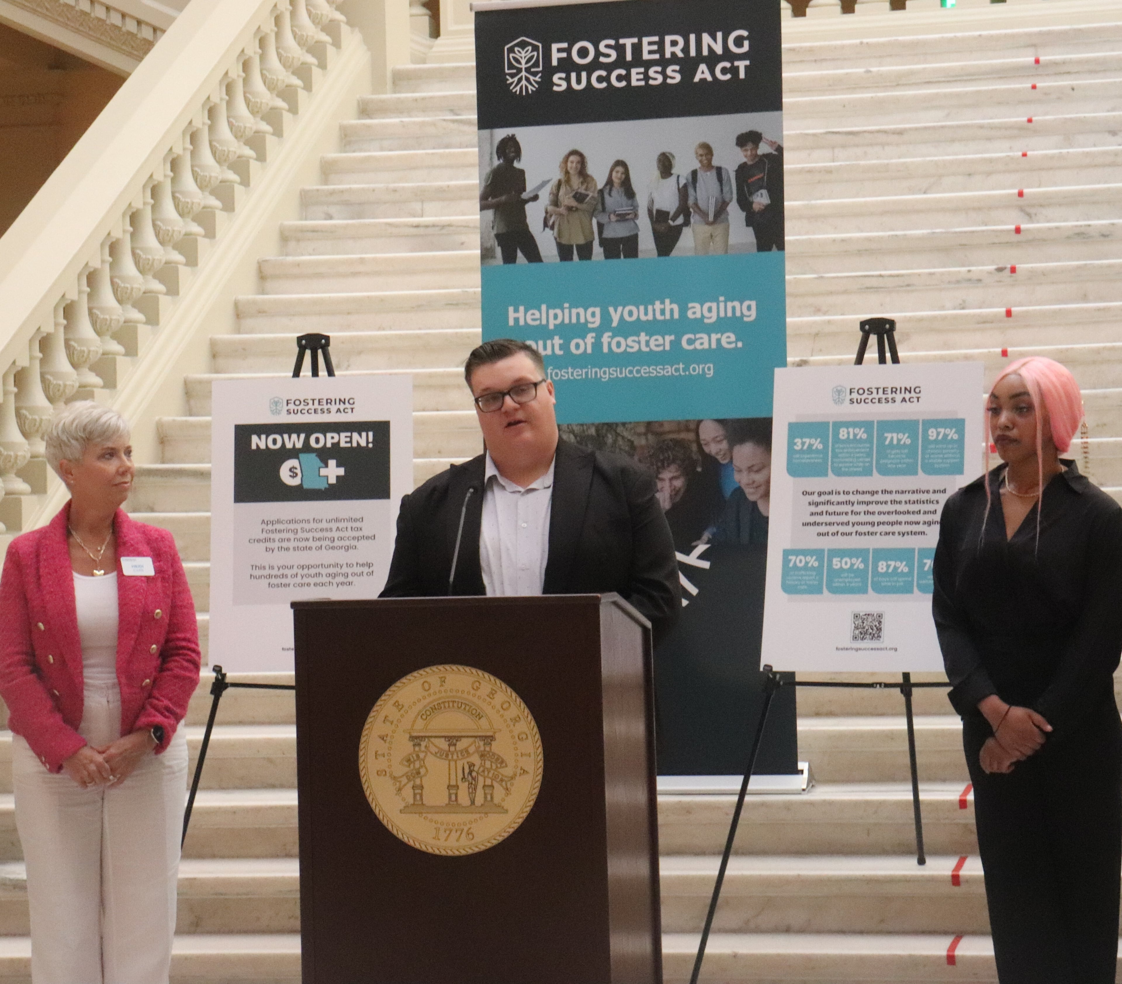 Michael Conger aged out of Georgia's foster care system but received help from a new tax credit program to assist former foster kids. During a July 1 news conference, he appeared with Heidi Carr (left), who directs a nonprofit that helps distribute funds from the program, and Jazmin Edwards, who also uses the program. (Anisah Muhammad/AJC)