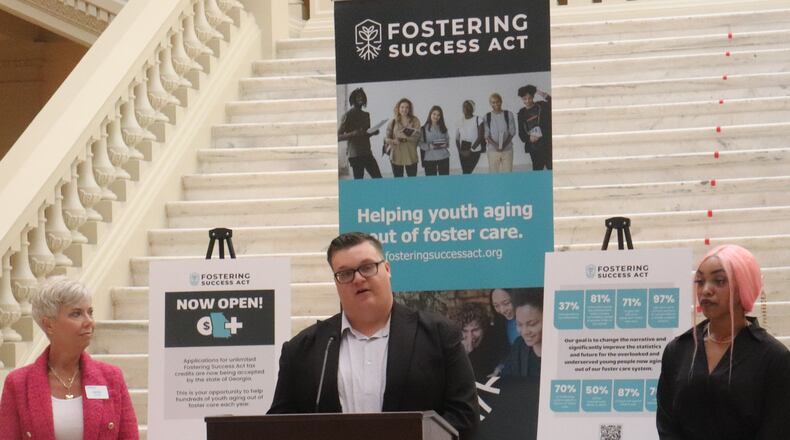 Michael Conger, 25, is aged out of Georgia's foster care system and has been receiving help from a new tax credit program to assist former foster kids. During a July 1 news conference at the Georgia State Capitol, he appeared with Heidi Carr (L), who directs a nonprofit that helps distribute funds from the tax credit program and Jazmin Edwards, who also utilizes the program. (Credit: Anisah Muhammad/AJC)