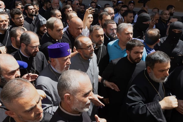 Mikael Ajapahyan, Archbishop of Gyumri and Shirak, center, and Catholicos Karekin II, center left, walk surrounded by other priests as Armenian National Security Service officers arrive to arrest Ajapahyan, at Echmiadzin, the seat of the Armenian Apostolic Church outside Yerevan, Armenia, Friday, June 27, 2025. (Grigor Yepremyan, PAN Photo via AP)