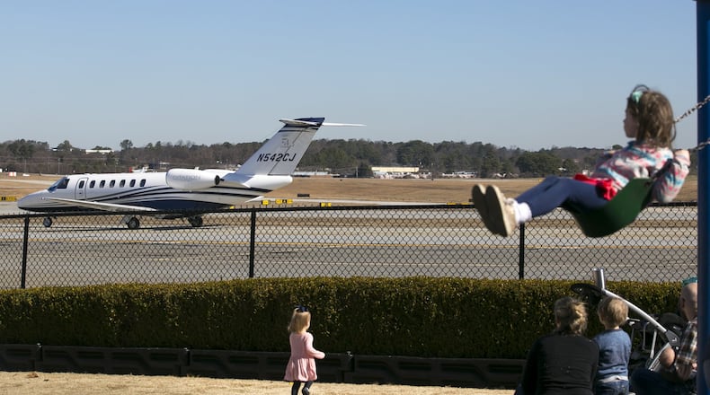 Kids watch from a playground as a jet moves along the tarmac at DeKalb-Peachtree Airport on Feb. 2, 2019. (Casey Sykes for The Atlanta Journal-Constitution)