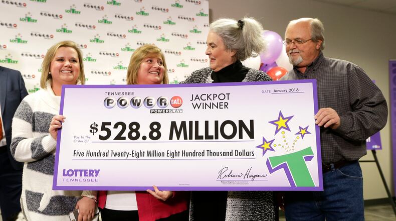 Rebecca Hargrove, second from right, president and CEO of the Tennessee Lottery, presents a ceremonial check to John Robinson, right; his wife, Lisa, second from left; and their daughter, Tiffany, left; after the Robinson's winning Powerball ticket was authenticated at the Tennessee Lottery headquarters Friday, Jan. 15, 2016, in Nashville, Tenn. The ticket was one of three winning tickets in the $1.6 billion jackpot drawing. (AP Photo/Mark Humphrey)