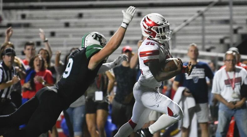 Milton's Ahmad Junearick runs for a TD as Roswell's Will Troutman dives in an attempt to make the tackle during Friday's game. (John Amis/Special)
