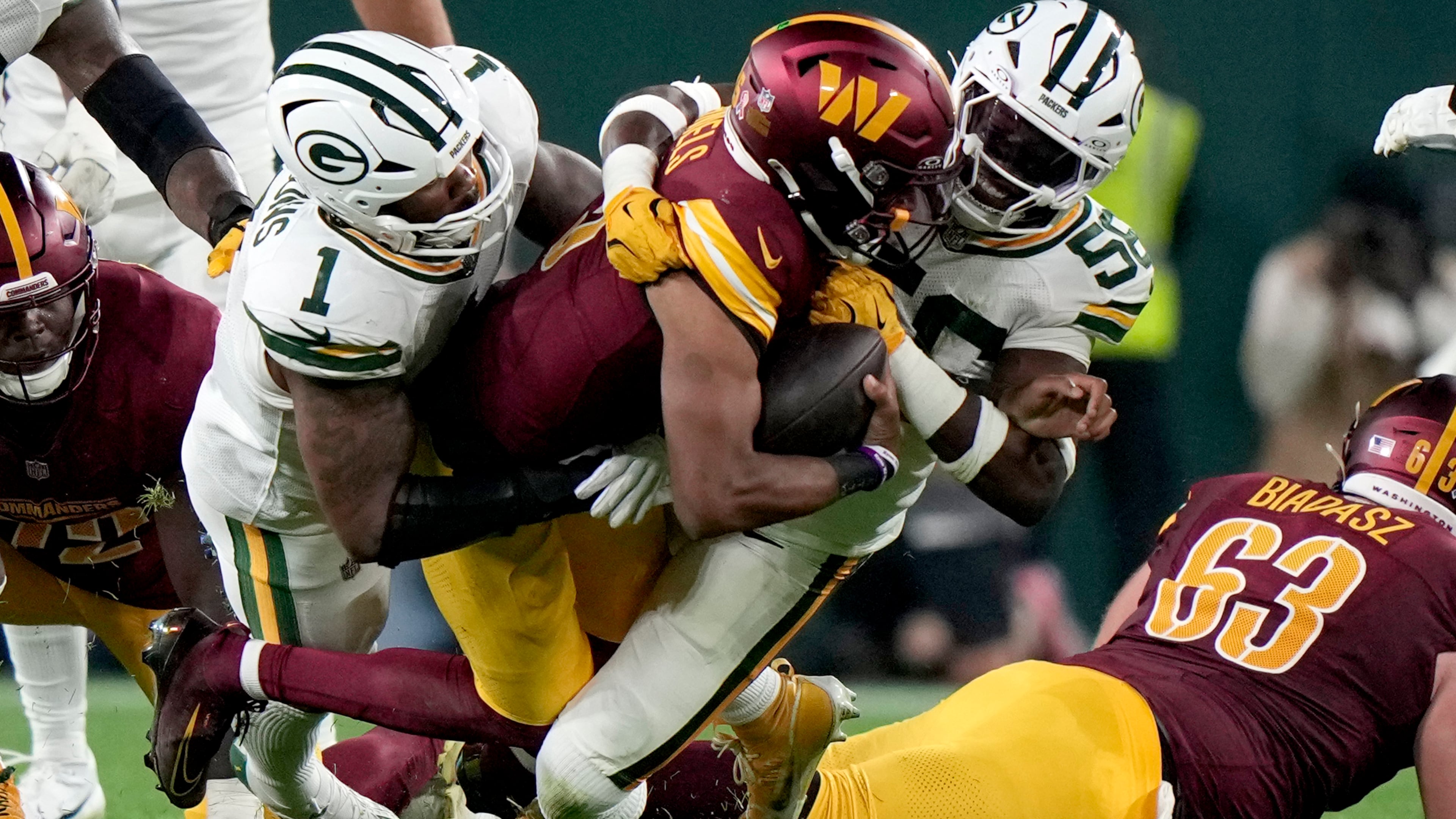 Washington Commanders quarterback Jayden Daniels is sacked by Green Bay Packers linebacker Edgerrin Cooper, right, and defensive lineman Micah Parsons (1) during the second half of an NFL football game Thursday, Sept. 11, 2025, in Green Bay, Wis. (AP Photo/Morry Gash)