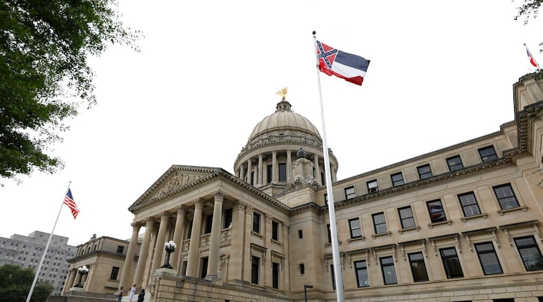 A Mississippi Highway Safety Patrol honor guard stands at attention as the retired Mississippi state flag is raised over the Capitol grounds one final time in Jackson, Miss., Wednesday, July 1, 2020. The banner was the last state flag with the Confederate battle emblem on it. (AP Photo/Rogelio V. Solis)