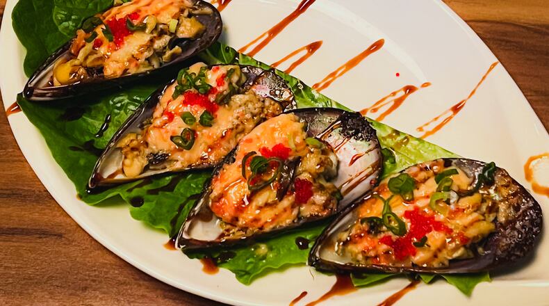 Baked green mussels at Mai Kitchen were a bit like oysters Rockefeller, only with Asian flavors. Henri Hollis/henri.hollis@ajc.com