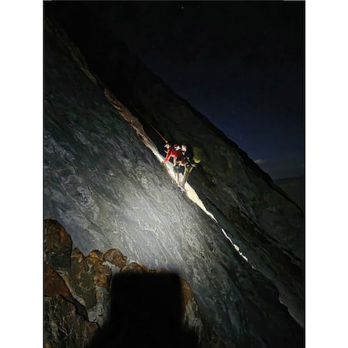 This photo released by Mono County Sheriff Search and Rescue, shows a rescuer with the man who was stranded, Rob Martin, right, after he was rescued on a ledge in the Sierra Nevada, Calif., on Aug. 22, 2026. (Mono County Sheriff Search and Rescue via AP)