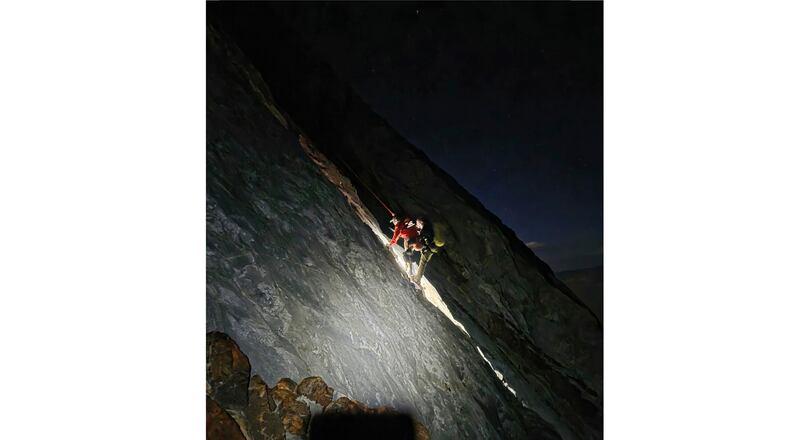 This photo released by Mono County Sheriff Search and Rescue, shows a rescuer with the man who was stranded, Rob Martin, right, after he was rescued on a ledge in the Sierra Nevada, Calif., on Aug. 22, 2026. (Mono County Sheriff Search and Rescue via AP)