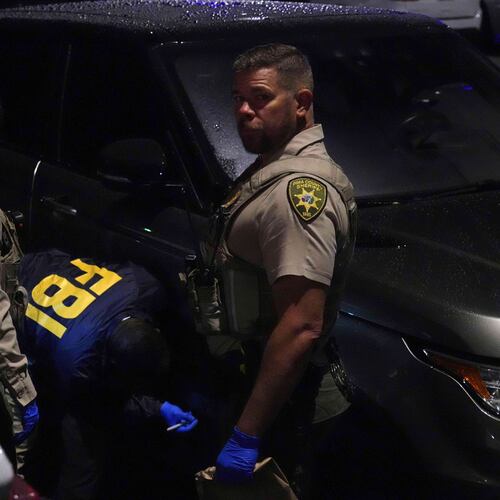 Pima County sheriff and FBI work on a Range Rover in a Culver’s parking lot in Tucson, Ariz. early Saturday, Feb. 14, 2026. (AP Photo/Ty ONeil)