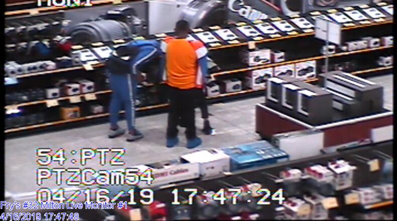 Milton police are searching for three shoplifting suspects accused of snatching high-priced camera equipment and then assaulting a loss prevention officer on their way out of the store.