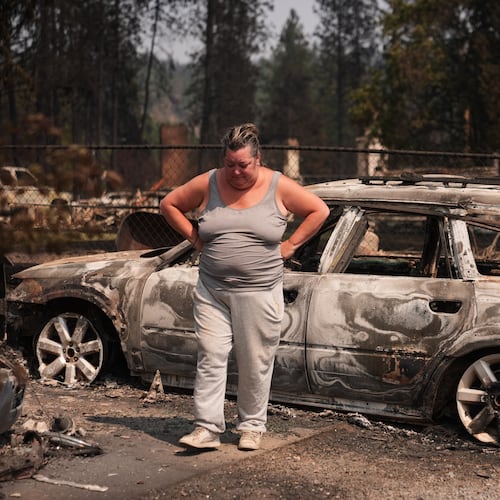 Michelle Angstrom reacts to her burned down home and property after a wildfire hit the northwest part of Spokane, Wash., Tuesday, Aug. 4, 2026. (AP Photo/Lindsey Wasson)