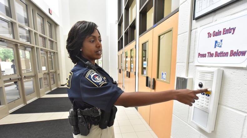 Gwinnet County Public Schools police officer Trakida Maldonado shows a security device at the main entrance of Northbrook Middle School on Wednesday, May 23, 2018. HYOSUB SHIN / HSHIN@AJC.COM