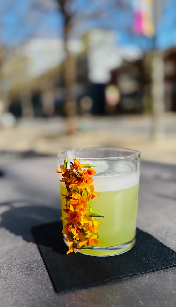 Smash the Basil at Casa Balam has a natural froth and springtime tropical flavors with a backbone of earthy smoke, along with a cascade of showy blooms on the glass. (Courtesy of Casa Balam)