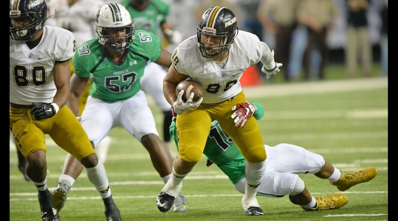 Colquitt County Shaun Bonner (88) gets tackled by Roswell Xavier Mckinney (15) in the GHSA Class AAAAAA State Championship at the Georgia Dome on Saturday December 12, 2015. HYOSUB SHIN / HSHIN@AJC.COM