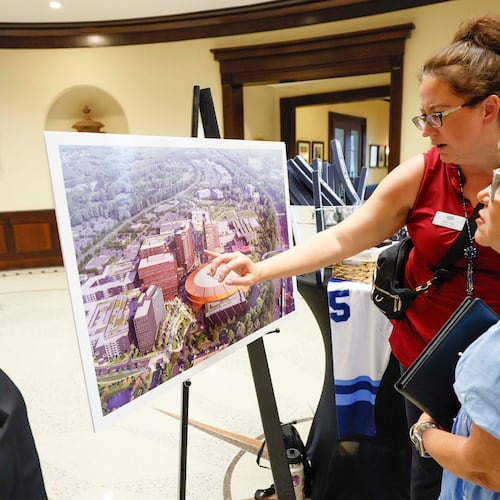 North Point rep Allison Icard presents a rendering of the redevelopment design for North Point Mall to Robbie Rebekah Gring in the Alpharetta City Hall Council Chamber on Monday, Aug. 24, 2026, before a public hearing where the city voted to clear the way for the mall's redevelopment into a sports-anchored entertainment district if the NHL awards the effort an expansion team. (Miguel Martinez/AJC)