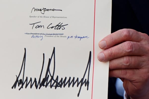 President Donald Trump holds his signed his signature bill of tax breaks and spending cuts at the White House, Friday, July 4, 2025, in Washington. (AP Photo/Julia Demaree Nikhinson)