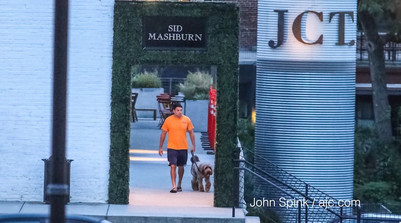 A man walks outside JCT Kitchen & Bar Tuesday morning. Late Monday, a robber shot a man in the parking lot, chased him inside the popular Midtown restaurant and continued firing, Atlanta police said. JOHN SPINK / JSPINK@AJC.COM