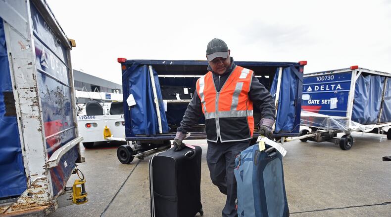 Delta baggage crew Stanley Hooks loads bags at Hartsfield-Jackson International Airport on Wednesday, February 27, 2019. HYOSUB SHIN / HSHIN@AJC.COM