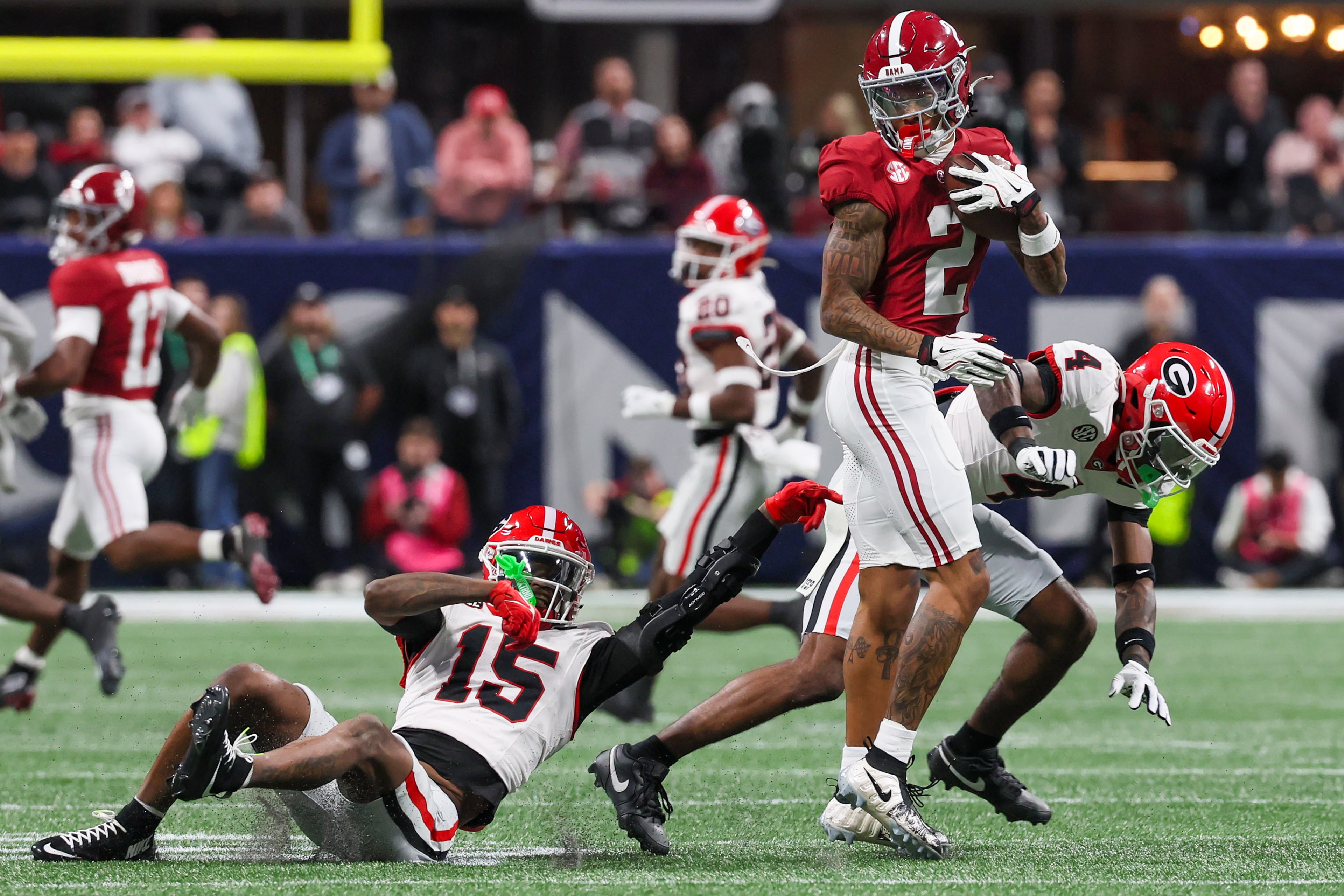 Alabama wide receiver Ryan Williams (2) makes a catch against Georgia defensive backs Demello Jones (15) and Kj Bolden (4) during the first half of the SEC Championship game at Mercedes-Benz Stadium, Saturday, Dec. 6, 2025, in Atlanta. (Jason Getz / AJC)