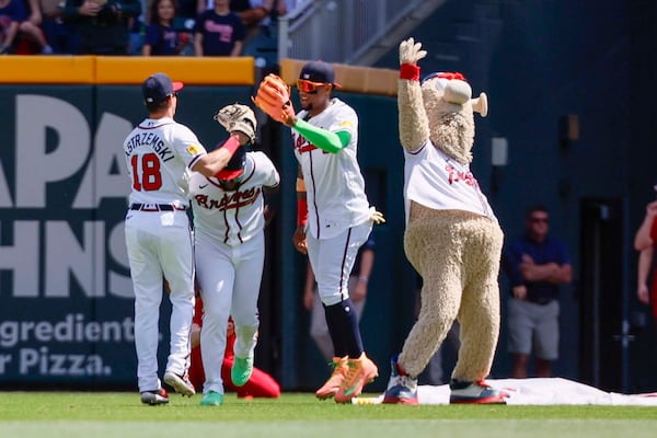 Blooper celebrates with Braves outfielders after their April 1 win over the Athletics. (Miguel Martinez/AJC)