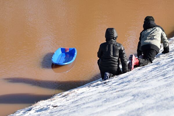 January 7, 2017, Alpharetta - Hudson Spencer, 10, left, and Christopher Bradburn, 11, right, watch as their sled drifts away in a pond in Alpharetta, Georgia, on Saturday, January 7, 2017. Most of Central and North Georgia woke up to snow and ice following a winter storm warning. (DAVID BARNES / DAVID.BARNES@AJC.COM)