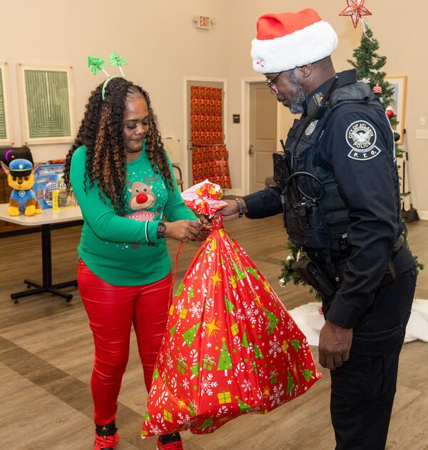 Event coordinator Shacole Pearman and Atlanta Police Officer Russel Stanio prepare gifts for kids in the Amani Place Apartment Homes community Center. 
PHIL SKINNER FOR THE ATLANTA JOURNAL-CONSTITUTION