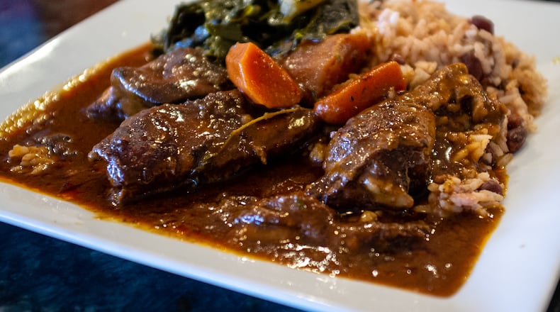 The brown stew chicken with rice and peas and collard greens at Rodney's Jamaican Soul Food. CONTRIBUTED BY HENRI HOLLIS