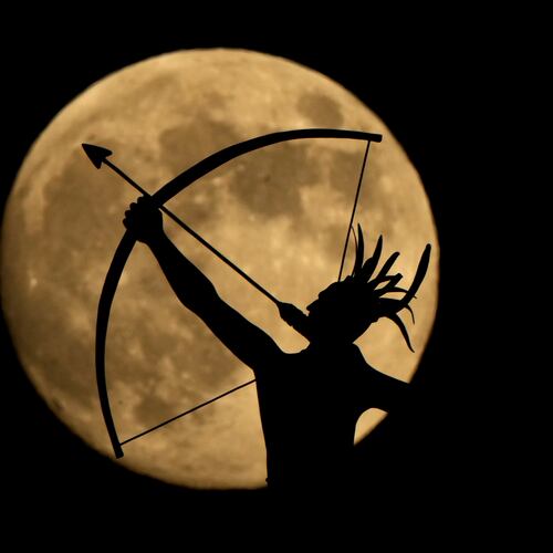 FILE - The bronze sculpture titled "Ad Astra," depicting a Kansa warrior, perched atop the Kansas State Capitol dome, is silhouetted against the nearly full moon, Nov. 14, 2024, on the eve of the final supermoon of the year in Topeka, Kan. (AP Photo/Charlie Riedel, File)