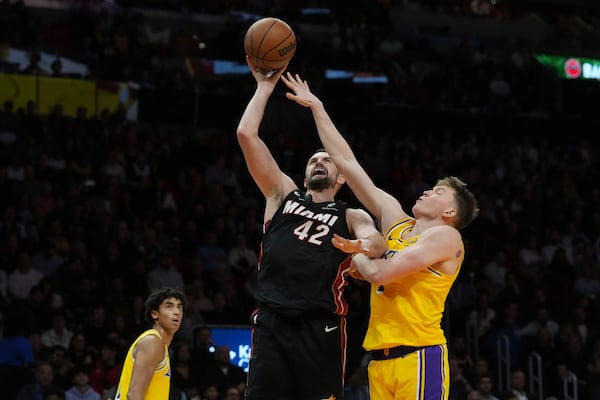FILE - Miami Heat forward Kevin Love (42) drives to the basket as Los Angeles Lakers guard Dalton Knecht (4) defends during the second half of an NBA basketball game, Dec. 4, 2024, in Miami. (AP Photo/Marta Lavandier, File)