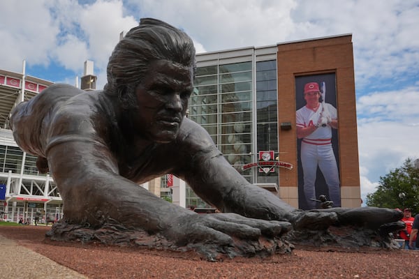 A bronze statue and a banner of former Cincinnati Reds player Pete Rose are seen outside the Great American Ball Park, Tuesday, May 13, 2025, in Cincinnati. (AP Photo/Carolyn Kaster)