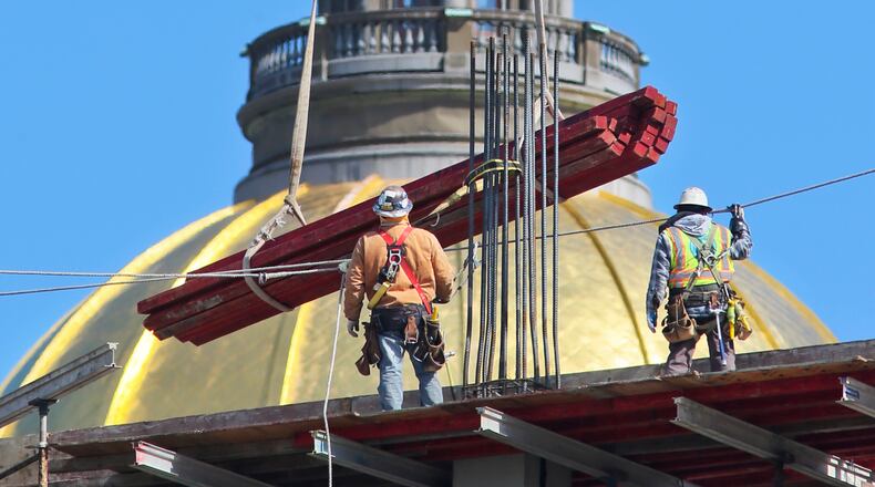 Construction workers move into place equipment on the rising BABS-002 parking deck adjacent to the Department of Transportation building on Capitol Avenue near Capitol Square in downtown Atlanta on Thursday, Mar. 21, 2013. The new parking lot will be 9-stories tall and just under 500-thousand square feet according to project manager, Matt Widmaier of Manhattan Construction Company, the general contractor. There will be two helicopter pads and the building will have an exterior of Georgia marble. The parking deck will be for state workers and legislators and is scheduled for completion in October of 2013.