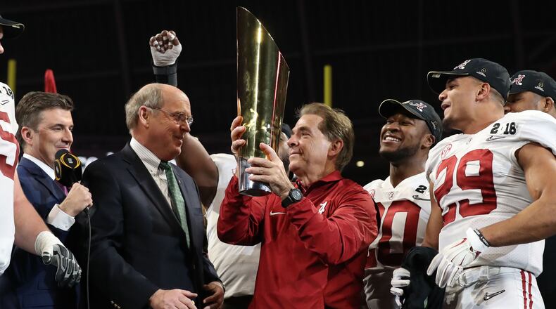 College Football Playoff executive director Bill Hancock awards a national championship trophy to Alabama coach Nick Saban. (File photo.)