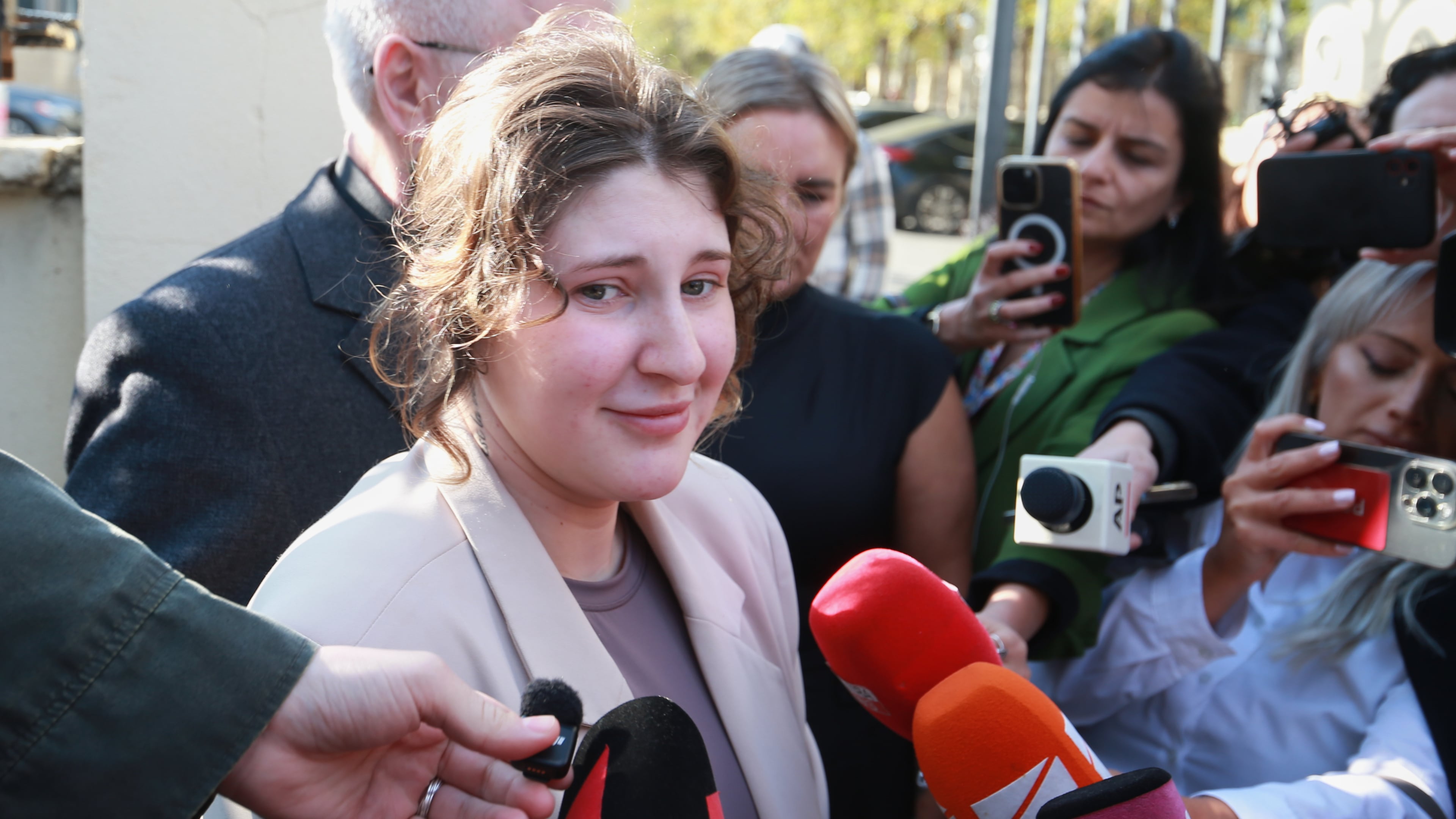 Bella May Culley, front left, 19-year-old, who was arrested upon arrival at the Tbilisi Airport in May and accused of attempting to smuggle marijuana and hashish into the country, speaks to journalists after she was released from prison near the court building in Tbilisi, Georgia, on Monday, Nov. 3, 2025, as her mother Lyanne Kennedy, stands behind. (AP Photo/Zurab Tsertsvadze)