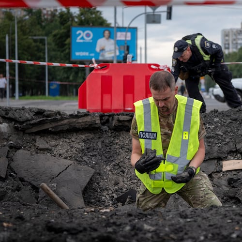 A sapper examines the impact site of a Russian missile in a residential area of Kyiv, Saturday, July 11, 2026. (AP Photo/Dan Bashakov)