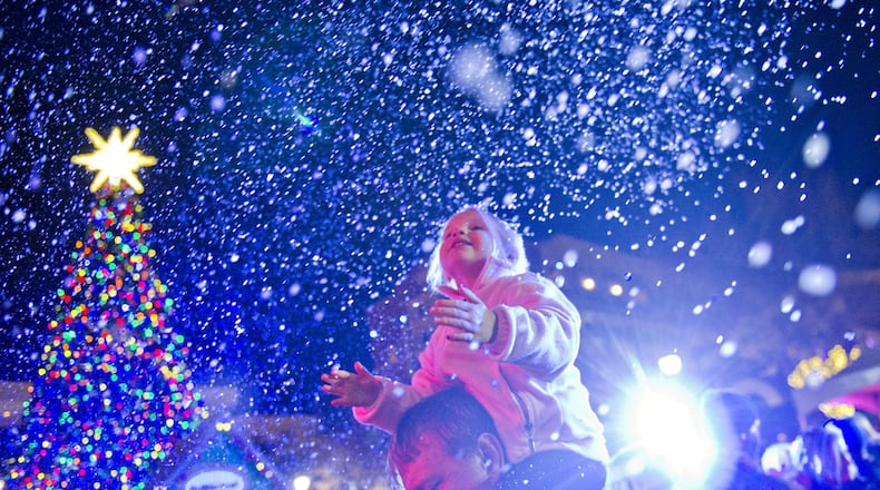 Don Johnson (left) holds his daughter Tyler on his shoulders as snow falls at Atlantic Station in Atlanta during the annual Christmas tree lighting on Nov. 23, 2013. The all-day celebration had live music, arts, live reindeer, delicious winter treats, and activities for the whole family. This year’s tree lighting at Atlantic Station will be Saturday, Nov. 21. JONATHAN PHILLIPS / SPECIAL